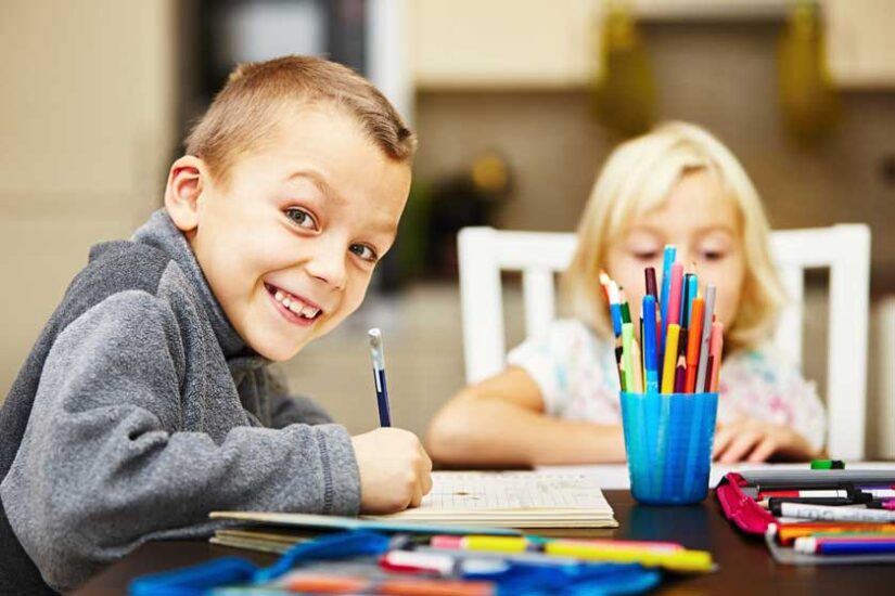 A kid writing in his worksheet.